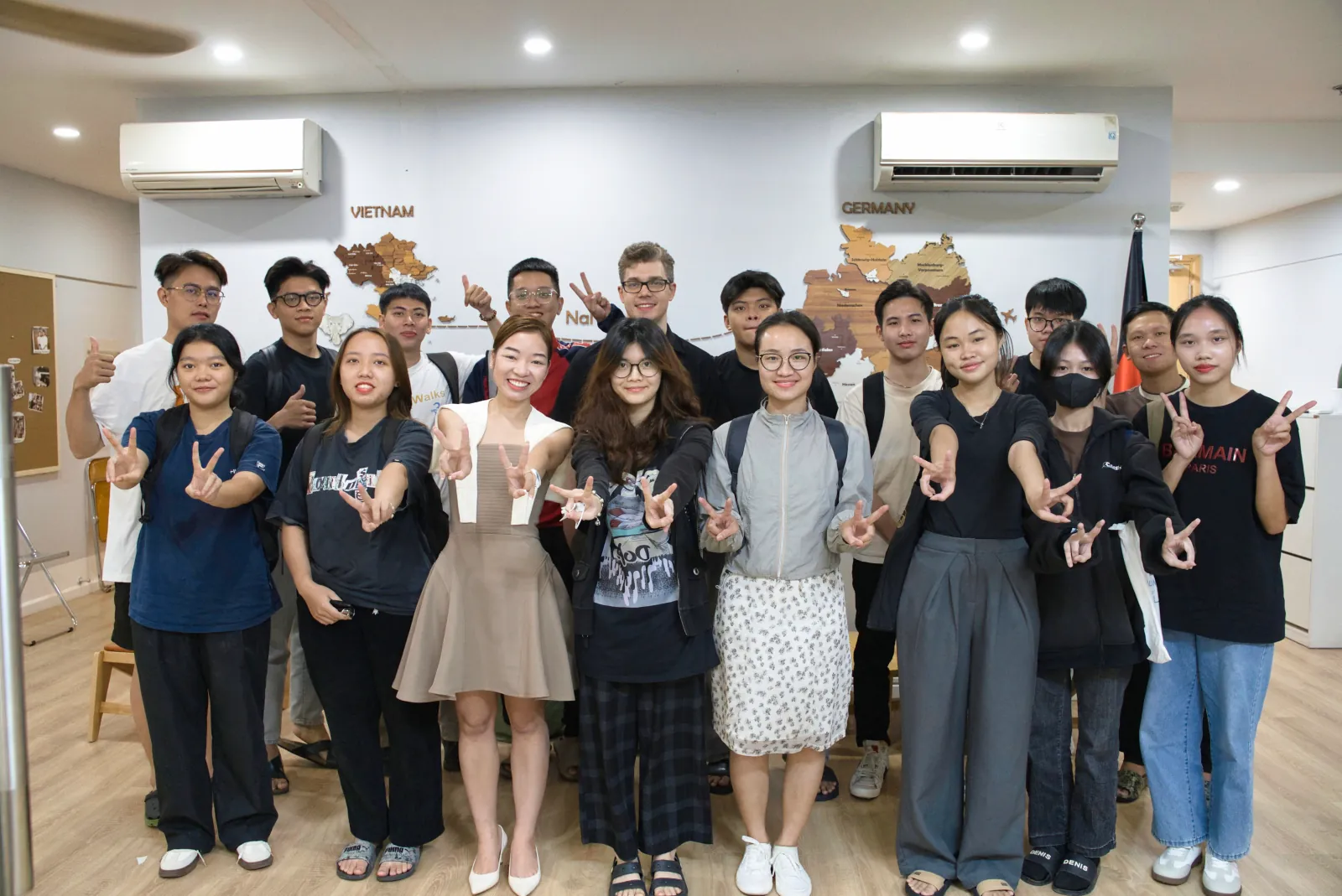 Học viên NaNu NaNa chụp ảnh trước bản đồ Việt Nam và Đức