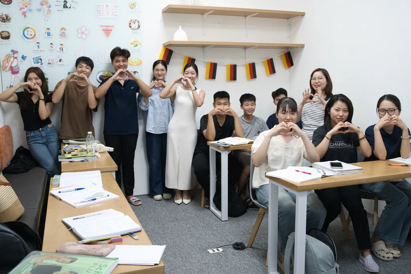 Lớp học tiếng Đức tại NaNu NaNa, học viên ngồi học với vở ghi và cờ Đức